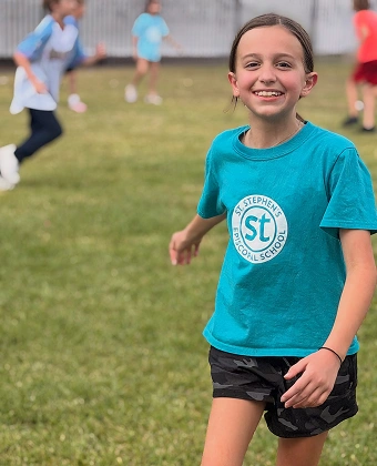 Smiling child running on a grassy field during outdoor play